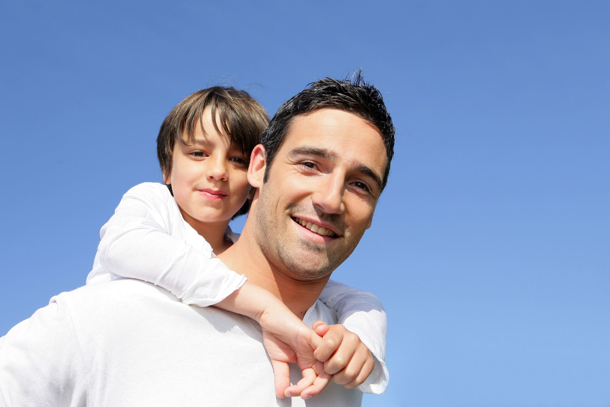 Boy hugging dad from behind