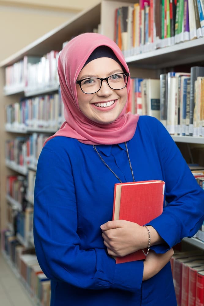 Mom in hijab volunteering in school library