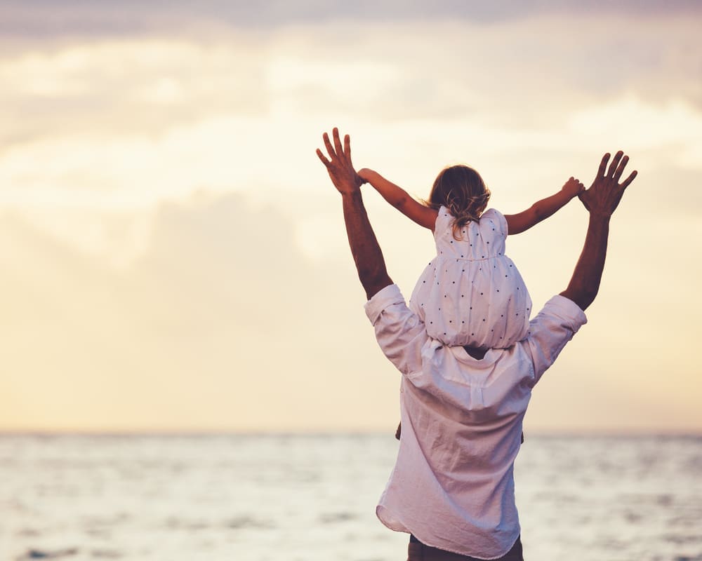 Girl sitting on dad's shoulders