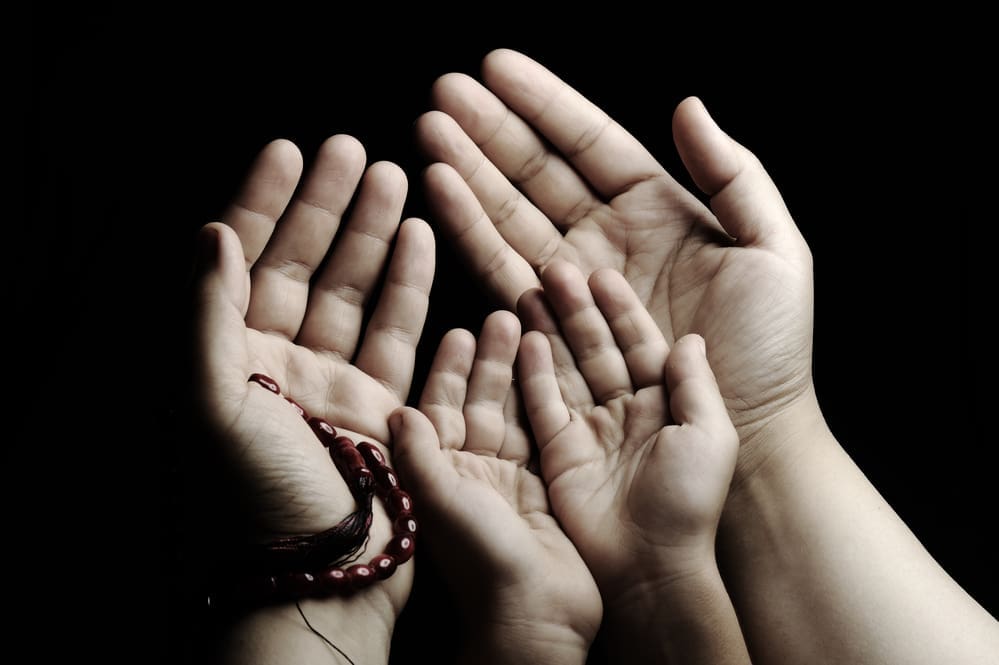 parent child's hands making dua