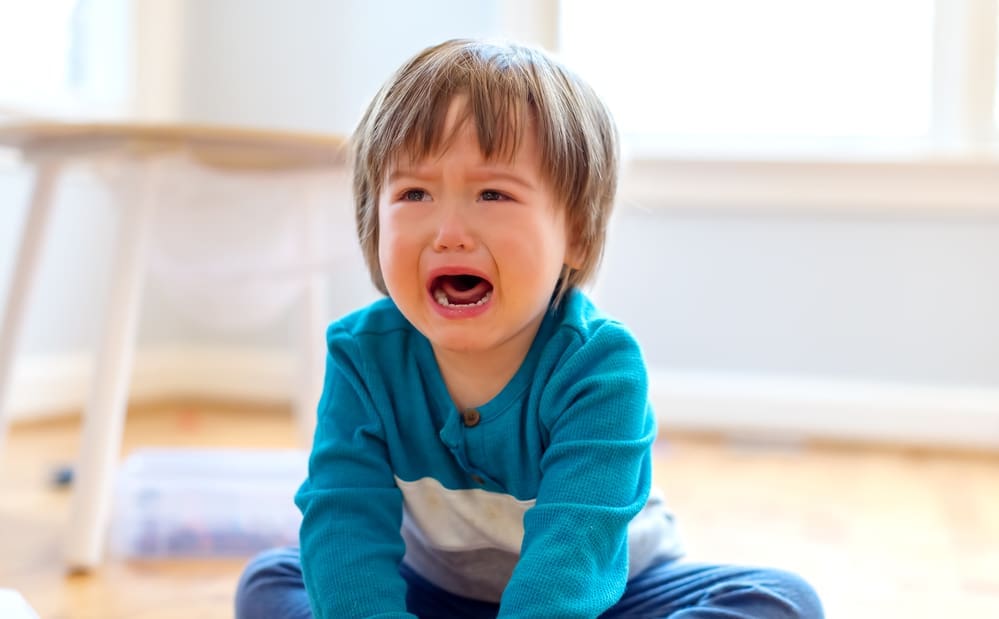 crying toddler boy biting